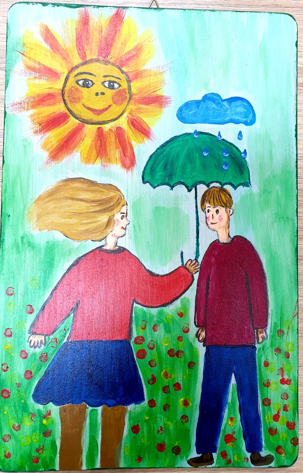 Dziewczynka trzyma parasol nad chłopcem